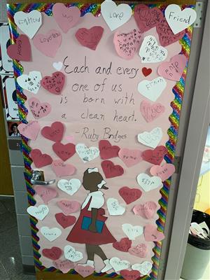 Photo of bulletin board with red, white and pink cutout hearts surrounding a quote from Ruby Bridges.